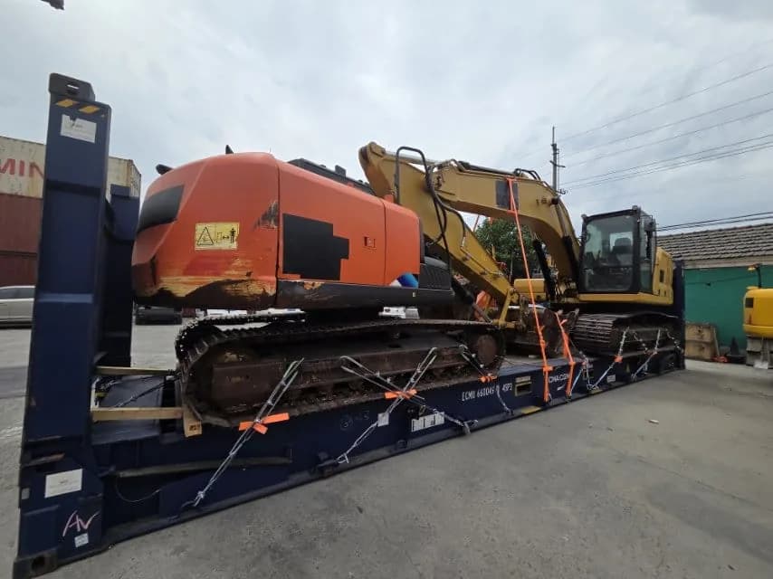 Excavadora y maquinaria pesada asegurada sobre un camión de plataforma de ALC Mudanzas