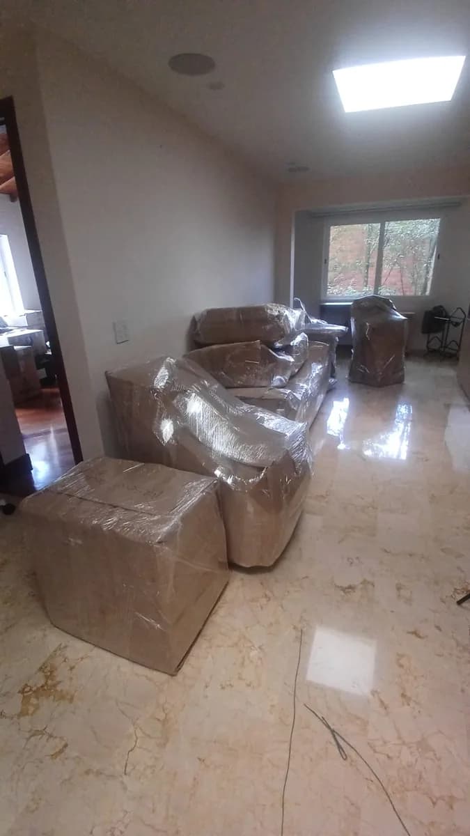 Salas y muebles embalados en un apartamento, listos para la mudanza